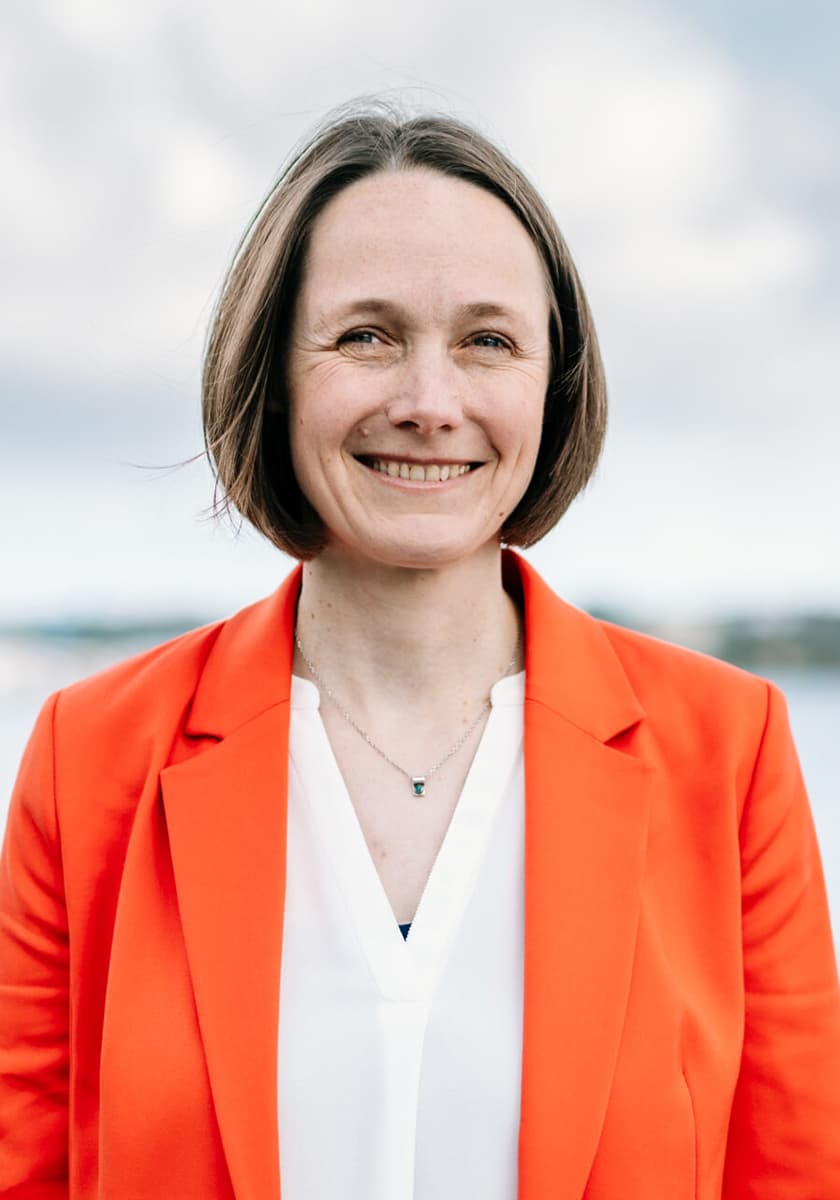 Ingrid Nestle vor grauen Wolken und dem Meer in Roter Windjacke