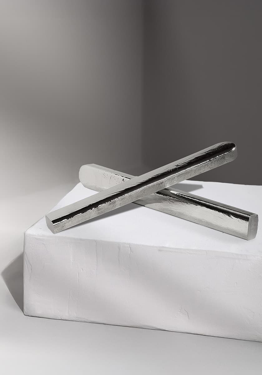 zwei silberfarbene Germaniumstäbe, über Kreuz liegend, auf einer weißen Steinbox mit subtilem Lichtspiel